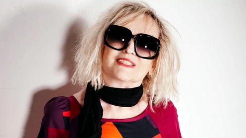 Photo of the late Annie Nightingale wearing big round sunglasses and a red patterned shirt