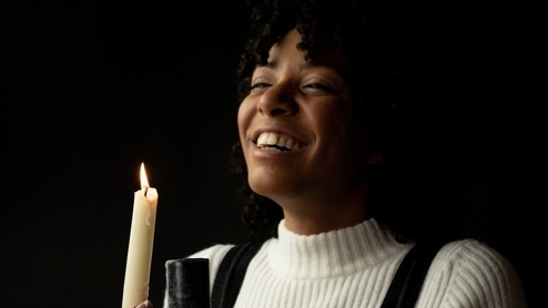 Photo of DJ Holographic laughing and holding a candle