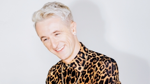 Photo of Denis Sulta wearing a leopard print shirt and gold necklace