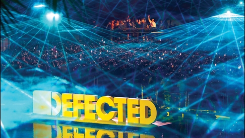 Photo of the yellow Defected logo alongside strobing lights