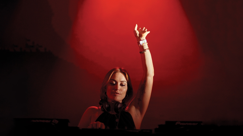 Arielle Free DJing with her hand in the air