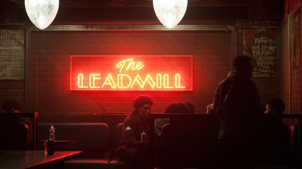 Photo of a red glowing The Leadmill sign inside the venue.