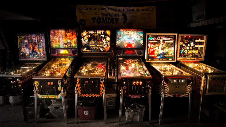 Photo of six vintage pinball machines.