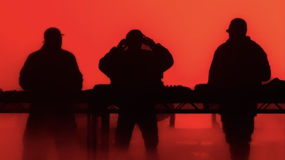Photo of Swedish House Mafia outlined in shadows against a red background