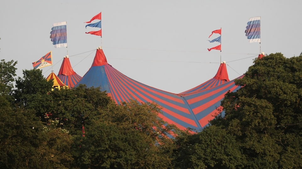 Photo of the tents above the forest skyline at Glastonbury 2023