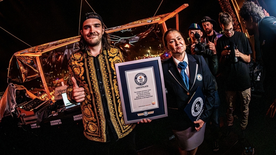 Photo of Reinier Zonneveld holding his world-record certificate next to a representative from the Guinness World Records