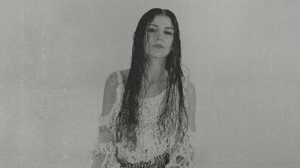 Black and white grainy photo of Marina Herlop wearing a white lace shirt
