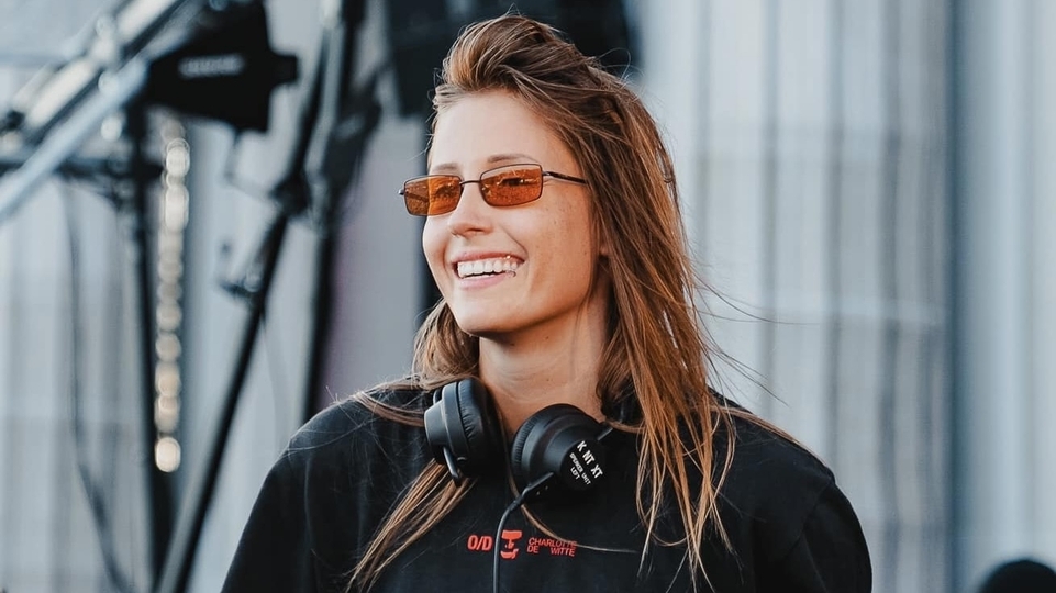 Photo of Charlotte de Witte smiling and wearing red sunglasses
