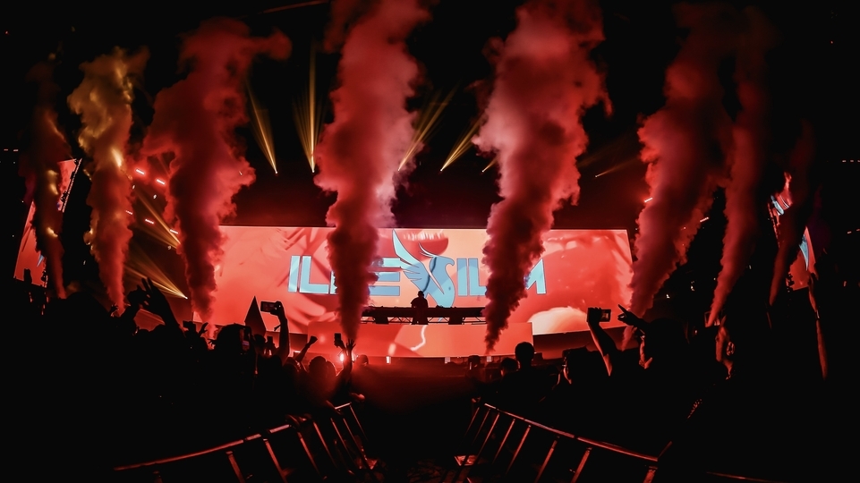 Photo of a DJ playing on stage at 808 Festival Bangkok 2022 with red pyro and a huge crowd