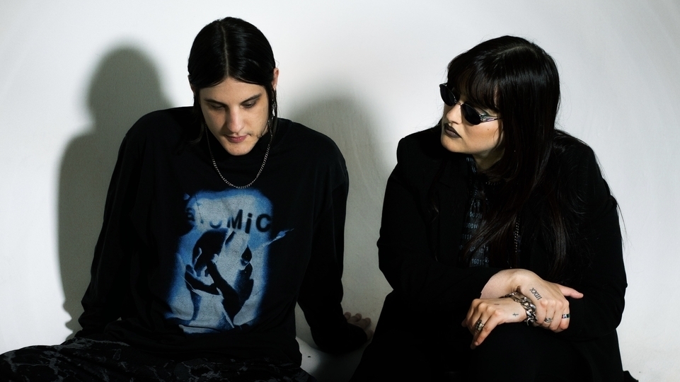 Photo of Lila Tirando a Violeta & Sin Maldita wearing black outfits and sitting side by side
