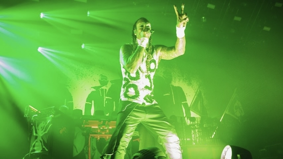 Photo of Maxim performing on stage beneath green lights