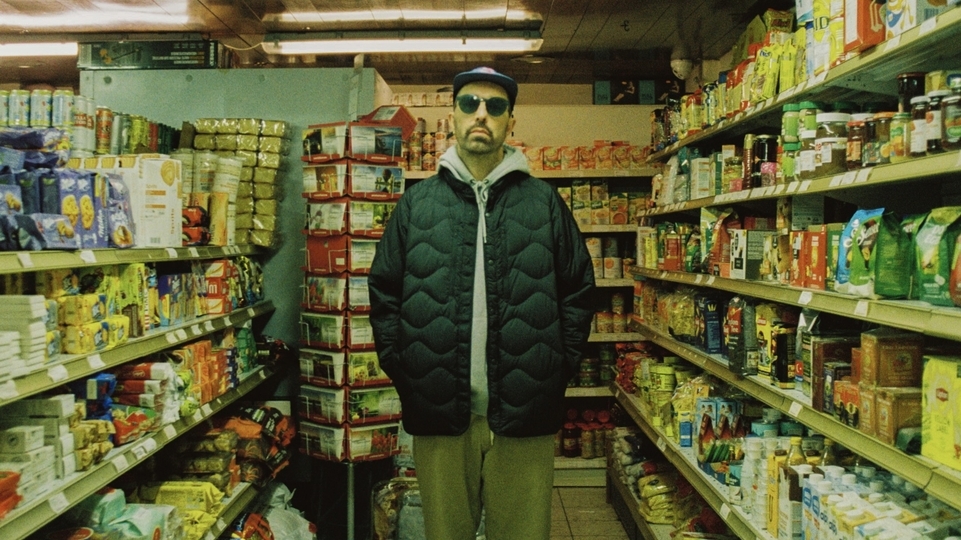 Photo of Lefto Early Bird in a corner shop wearing a hat and sunglasses