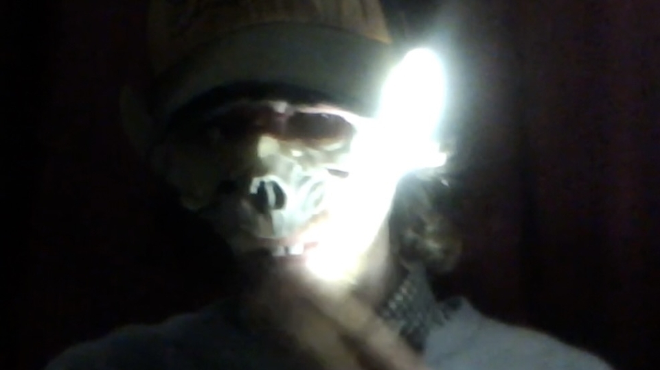 Photo of Ship Sket wearing an animal mask with a light flashing across his face