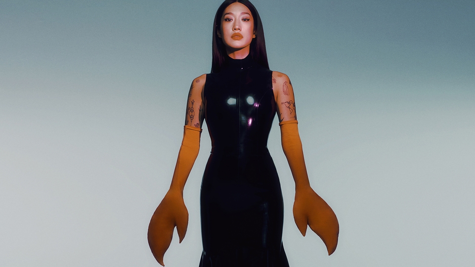 Peggy Gou wearing a long black dress and fake lobster claws
