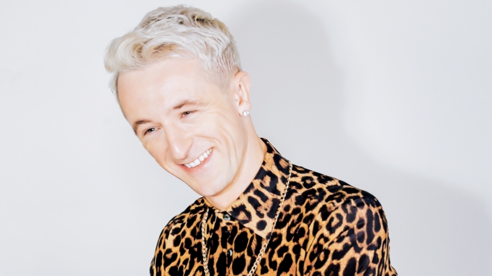 Photo of Denis Sulta wearing a leopard print shirt and gold necklace